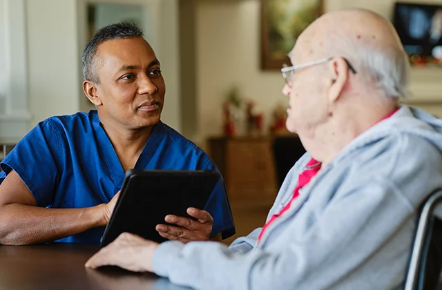 Clinician talking to hospice patient in a nursing facility